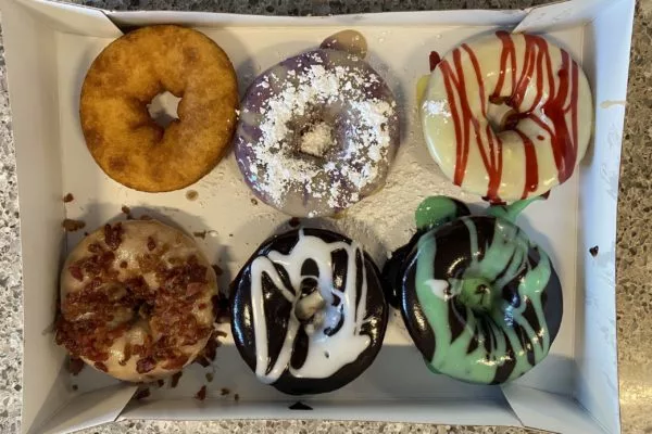 Six donuts of varying colors and toppings | Multiple Locations