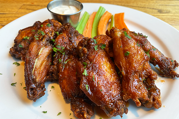 A plate of chicken wings with carrots and celery in the background along with a ramequin of ranch | 794 North Highland Avenue NE, Atlanta, GA 30306