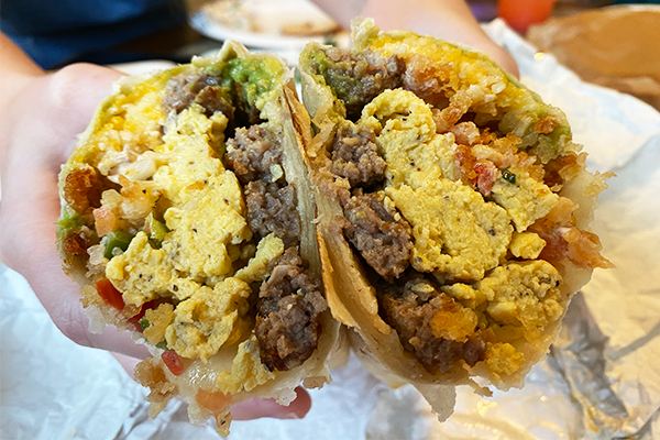 Breakfast burrito cut in half, showing eggs, pico de gallo, sausage, and more | 1700 S Lumpkin St, Athens, GA 30606