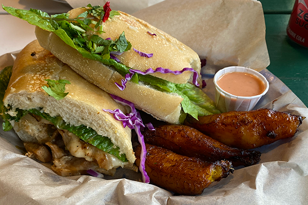 Chicken cubano sandwich with fried plantains and a white cup of pink sauce | 1427 South Lumpkin Street, Athens, GA 30605 