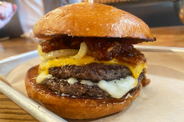 Double cheeseburger with tomato bacon jam and grilled onions | Multiple Locations