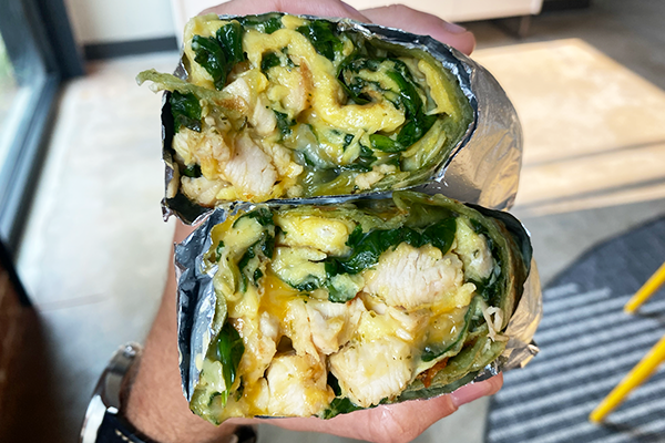 A stacked breakfast burrito wrapped in foil and stuffed with chunks of chicken, scrambled eggs, spinach, and cheese | 931 Monroe Dr NE, Atlanta, GA 30308