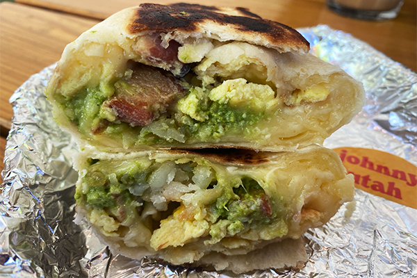 A breakfast burrito sliced in half and stacked one on top of another. The burrito has eggs, bacon, potatoes, and more. | 904 Memorial Dr SE, Atlanta, GA 30316