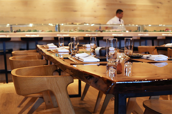 Set table with sushi bar and sushi chef in background