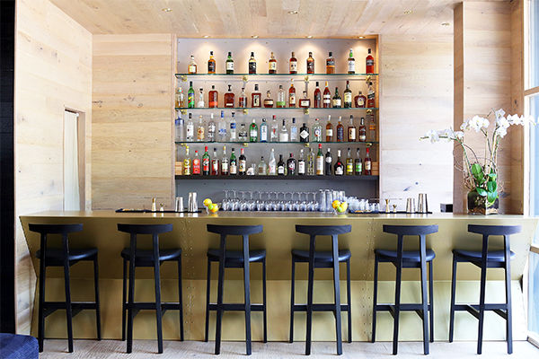 Bar with high chairs and several shelves of liquor