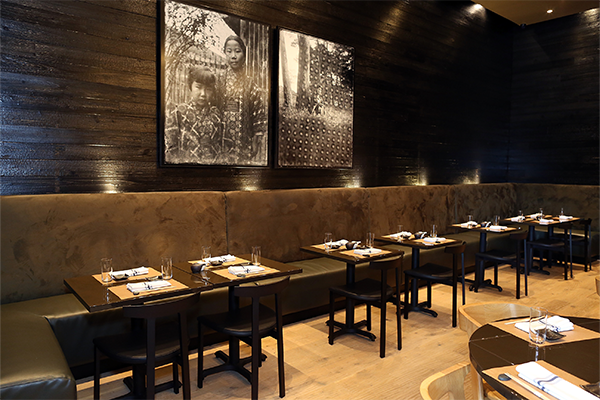 Dim interior of Umi with two framed photos on the wall and a line of booths