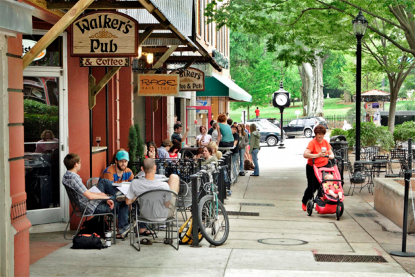 City block with Walker's Pub & Coffee in foreground and groups of people sitting outside | 128 College Ave, Athens, GA 30601